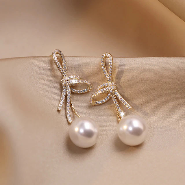 Aretes de Perlas con Lazo Brillante en Oro